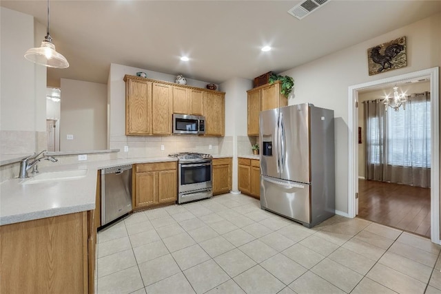 kitchen with pendant lighting, sink, light tile patterned floors, appliances with stainless steel finishes, and a chandelier