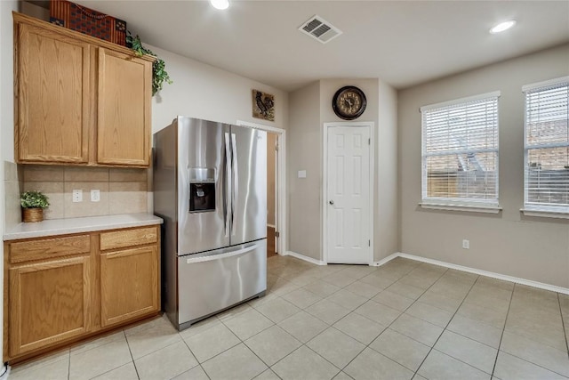 kitchen featuring decorative backsplash, stainless steel fridge with ice dispenser, and light tile patterned floors