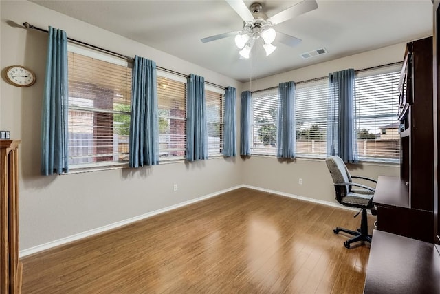 unfurnished office with ceiling fan and wood-type flooring