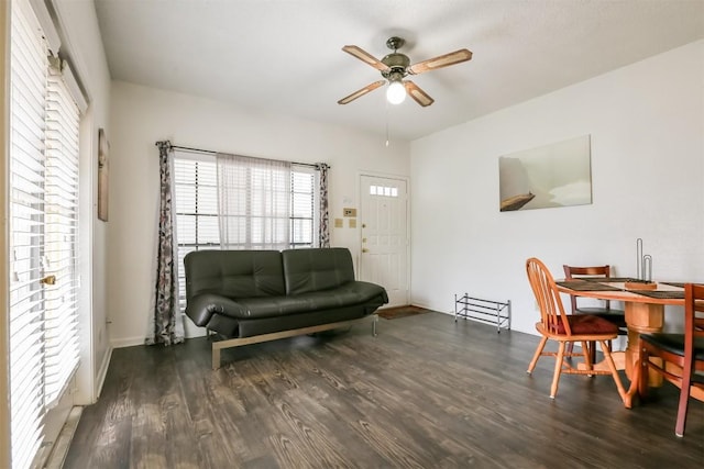 living room with dark hardwood / wood-style flooring, a wealth of natural light, and ceiling fan