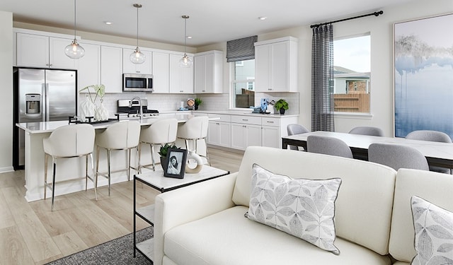 kitchen with pendant lighting, stainless steel appliances, and white cabinets