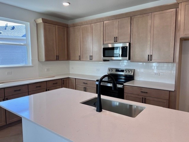 kitchen with stainless steel appliances, sink, and backsplash