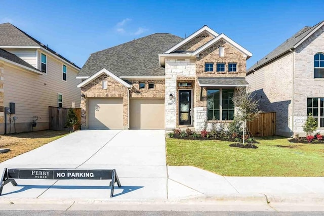 craftsman-style house featuring a garage, fence, a front lawn, and brick siding