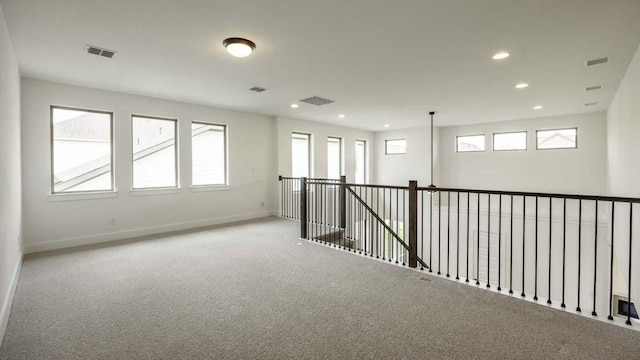 unfurnished room with healthy amount of natural light, carpet, recessed lighting, and baseboards