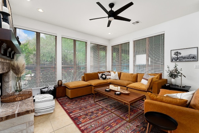 living room with tile patterned flooring, ceiling fan, and a fireplace