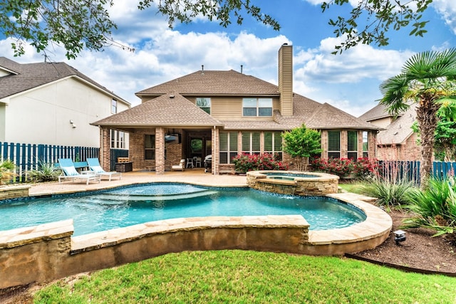 view of swimming pool featuring an in ground hot tub, pool water feature, and a patio