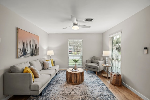 living room with wood-type flooring and ceiling fan