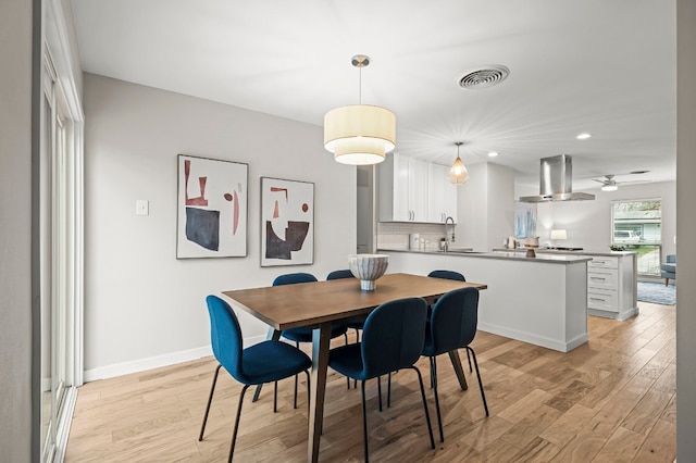 dining area featuring ceiling fan, sink, and light hardwood / wood-style floors