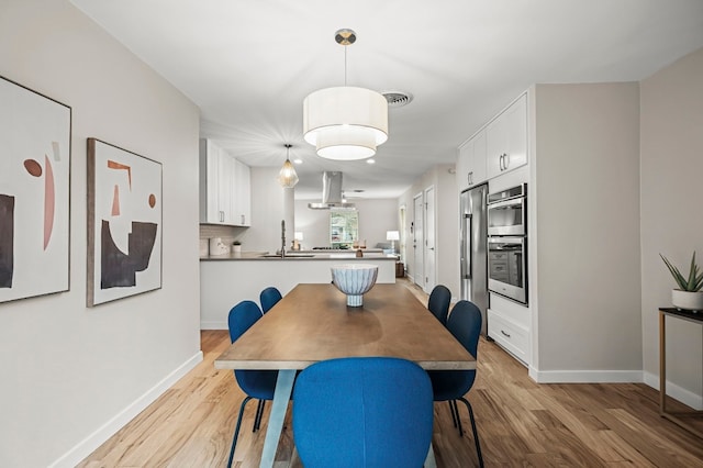 dining area with light hardwood / wood-style flooring and sink