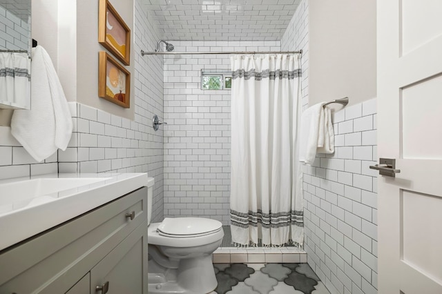 bathroom with tile patterned floors, a shower with curtain, vanity, tile walls, and toilet