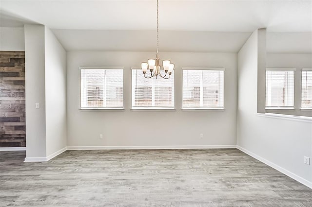 unfurnished dining area featuring a chandelier and light hardwood / wood-style floors