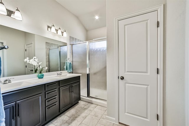 bathroom with tile patterned floors, vanity, lofted ceiling, and walk in shower