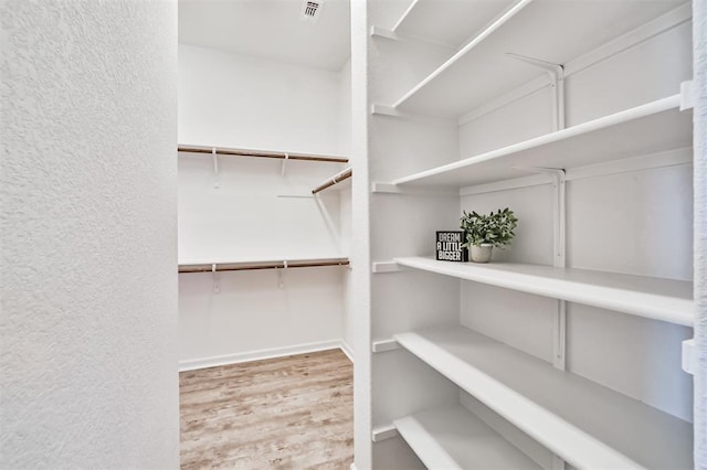 spacious closet featuring hardwood / wood-style floors