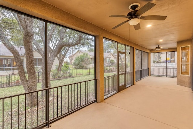 unfurnished sunroom featuring ceiling fan