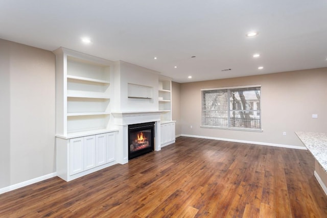 120 Ruellia Dr, Georgetown, TX 78633 - unfurnished living room with baseboards, dark wood-style flooring, and a glass covered fireplace