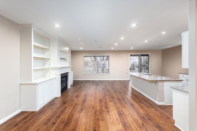 unfurnished living room with dark hardwood / wood-style flooring and sink