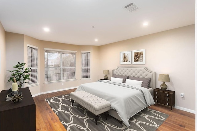 bedroom with recessed lighting, wood finished floors, visible vents, and baseboards