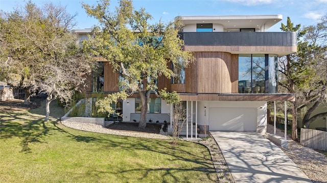 modern home featuring a balcony, a front yard, and a garage