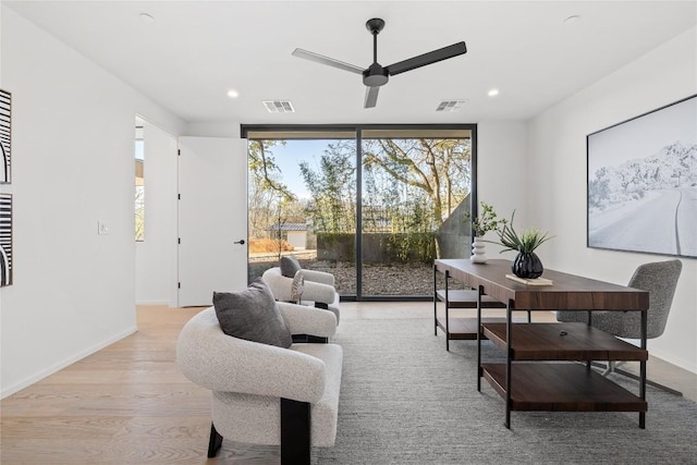 interior space with ceiling fan, light wood finished floors, visible vents, and baseboards