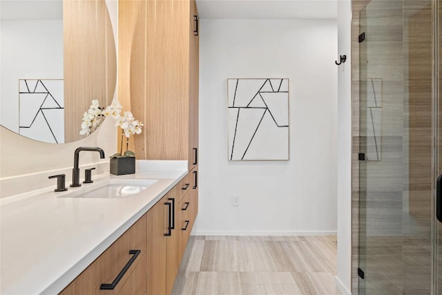 full bath with a stall shower, vanity, and baseboards