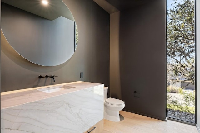 half bath featuring vanity, toilet, and wood finished floors