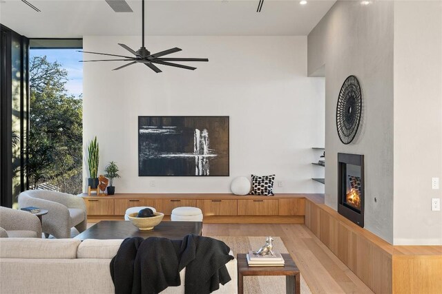 living room with floor to ceiling windows, ceiling fan, light hardwood / wood-style flooring, and plenty of natural light