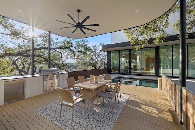 wooden deck featuring ceiling fan, a grill, and area for grilling