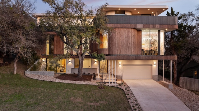 modern home featuring a balcony, a yard, and a garage