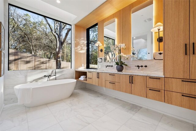 bathroom with a bathtub, tasteful backsplash, and vanity