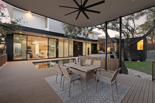 deck at dusk featuring ceiling fan