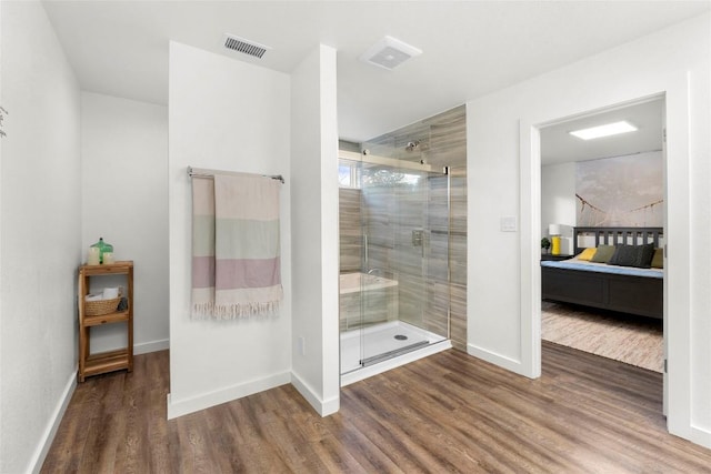 bathroom featuring a shower with shower door and wood-type flooring