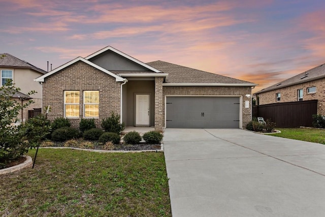 view of front of home with a garage and a yard