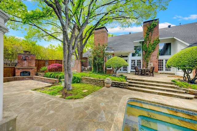 exterior space featuring an outdoor brick fireplace and french doors