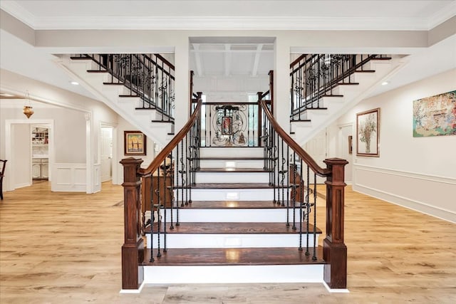 stairs featuring wood-type flooring and ornamental molding