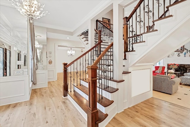 stairway featuring a chandelier, hardwood / wood-style floors, and ornamental molding