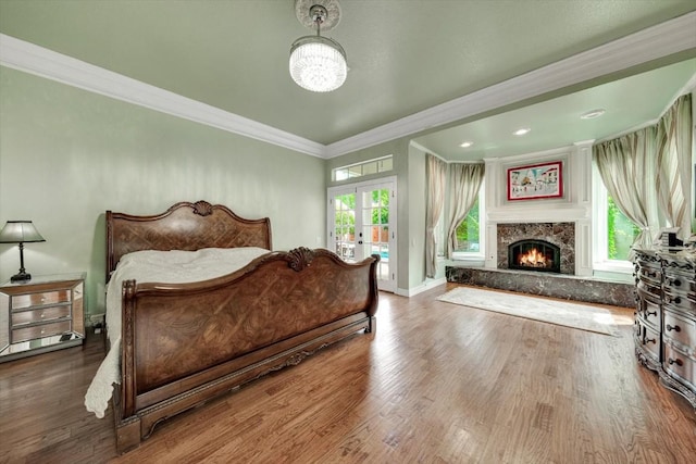 bedroom with a fireplace, hardwood / wood-style floors, french doors, and crown molding