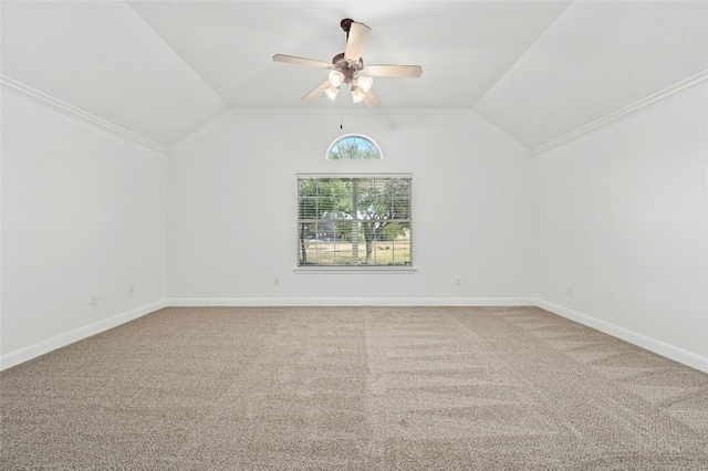 carpeted spare room featuring vaulted ceiling, ornamental molding, and ceiling fan