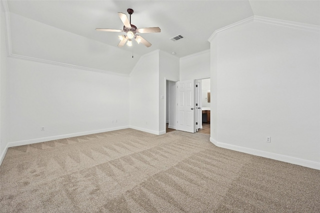 interior space with lofted ceiling, ceiling fan, ensuite bathroom, ornamental molding, and light carpet