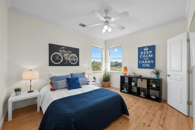 bedroom featuring light hardwood / wood-style floors, ceiling fan, and crown molding