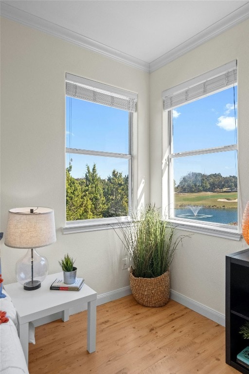 sitting room with a water view, crown molding, and light hardwood / wood-style floors