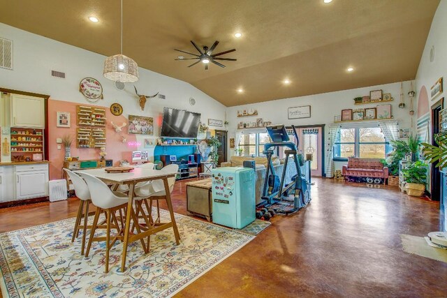 dining space featuring ceiling fan, concrete flooring, and vaulted ceiling