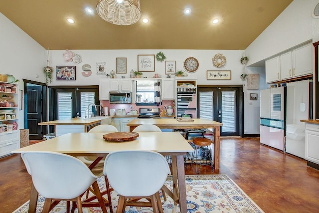 dining area featuring sink, high vaulted ceiling, and french doors