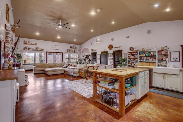 kitchen featuring butcher block counters, open shelves, finished concrete floors, a sink, and ceiling fan