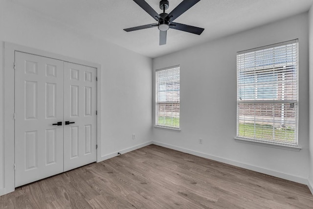 unfurnished bedroom with multiple windows, a closet, and ceiling fan