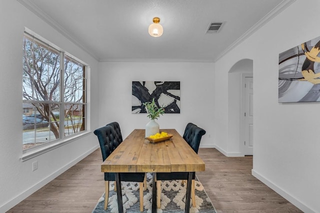 dining room with wood-type flooring and ornamental molding