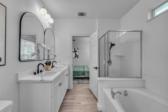 bathroom with shower with separate bathtub, vanity, and hardwood / wood-style flooring