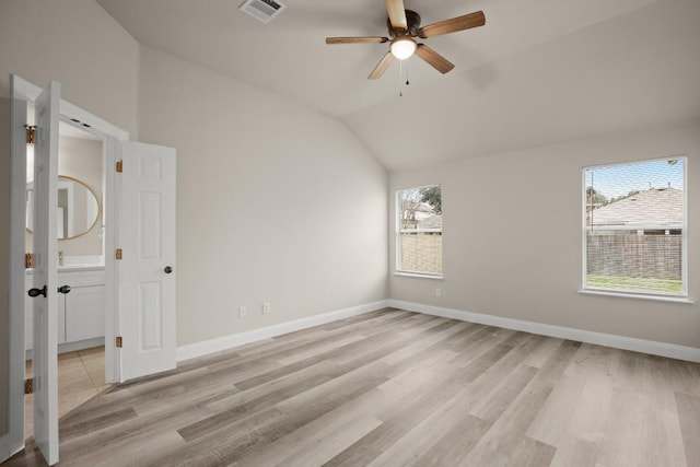 unfurnished room with ceiling fan, a healthy amount of sunlight, light hardwood / wood-style flooring, and vaulted ceiling