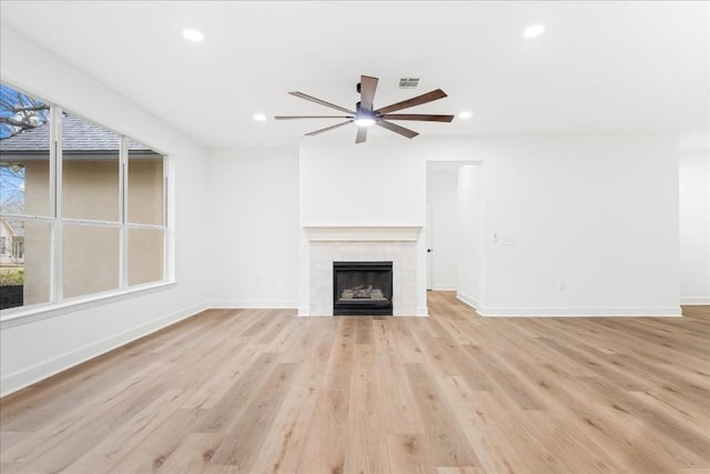 unfurnished living room with a fireplace, light hardwood / wood-style floors, and ceiling fan