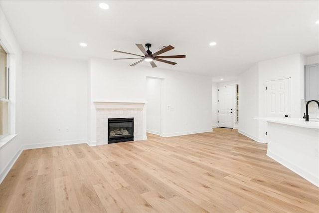 151 Dan Moody Trl, Georgetown, TX 78633 - unfurnished living room with ceiling fan, recessed lighting, light wood-type flooring, and a tiled fireplace