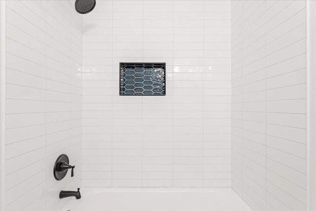 bathroom featuring tiled shower / bath